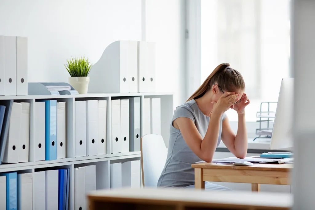 Une femme triste devant son bureau parce qu'elle ne peut plus travailler