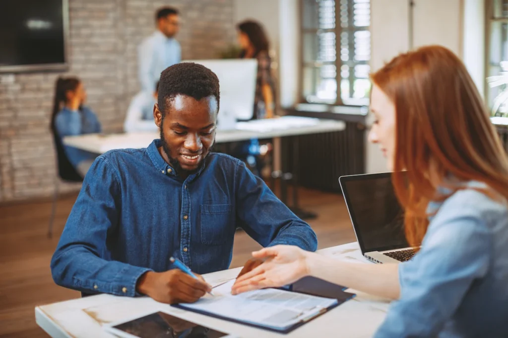 un jeune homme qui signe un contrat de stage dans une entreprise