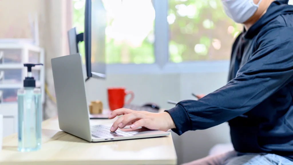 Un homme devant son ordinateur en train d'utiliser des outils No Code
